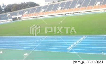 青いトラックと緑のフィールドが広がる美しい陸上競技場。爽やかなスポーツの風景をお届けします。 青いトラックと緑のフィールドが広がる美しい陸上競技場。爽やかなスポーツの風景をお届けします。 139894641