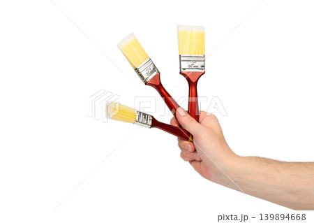 three paint brushes in a hand isolated on a white background three paint brushes in a hand isolated on a white background 139894668