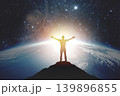 Silhouette of a man with raised hands against the backdrop of the planet and sunset. Elements of this image furnished by NASA 139896855