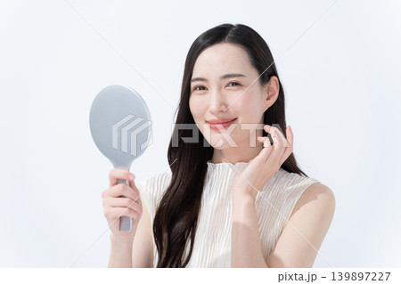 手鏡を見て肌のチェックをする女性 手鏡を見て肌のチェックをする女性 139897227