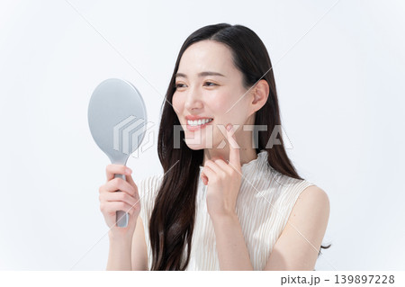 手鏡を見て肌のチェックをする女性 手鏡を見て肌のチェックをする女性 139897228
