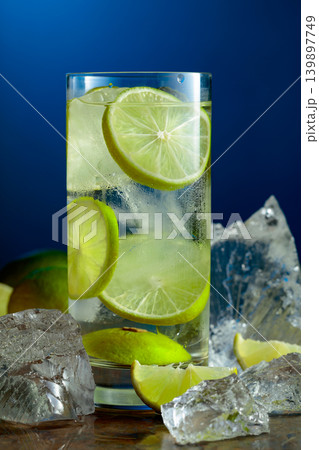 Cold refreshing drink with ice and lime in tall glass with water condensation drops. Cold refreshing drink with ice and lime in tall glass with water condensation drops. 139897749