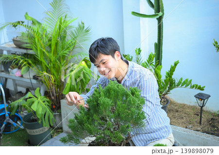 A man making bonsai pruning with precision care and craftsmanship A man making bonsai pruning with precision care and craftsmanship 139898079