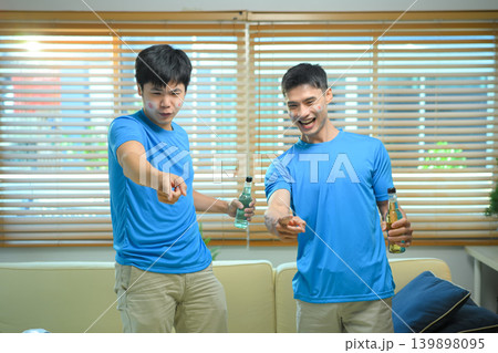 Friends celebrating soccer goal at home Friends celebrating soccer goal at home 139898095