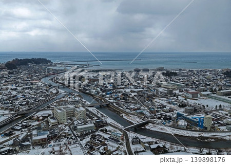 石川県輪島市の雪景色と港町を俯瞰した冬の空撮写真 139898176