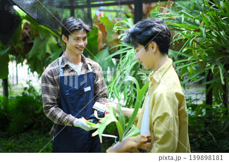 Customer paying by credit card at garden shop, showing modern payment and retail lifestyle Customer paying by credit card at garden shop, showing modern payment and retail lifestyle 139898181
