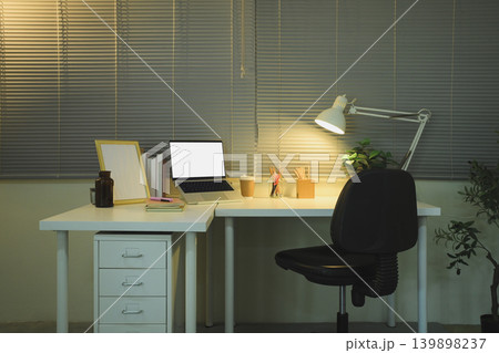 Night home office desk with laptop mockup and warm lamp lighting Night home office desk with laptop mockup and warm lamp lighting 139898237