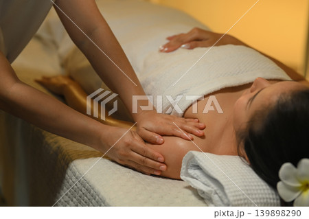 Closeup massage at spa with therapist in warm calm wellness room 139898290