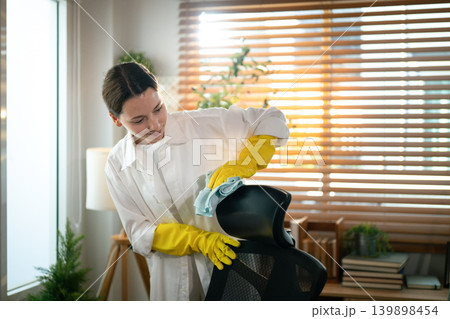 Caucasian Woman Cleaning Office Chair at Home Workspace Caucasian Woman Cleaning Office Chair at Home Workspace 139898454