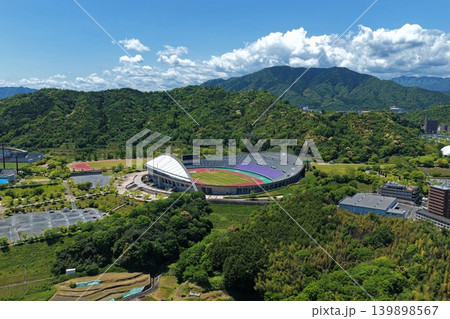 広島広域公園陸上競技場と緑の山々を俯瞰した空撮写真 広島広域公園陸上競技場と緑の山々を俯瞰した空撮写真 139898567