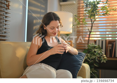 Woman enjoying a quiet moment with a glass of water Woman enjoying a quiet moment with a glass of water 139898734