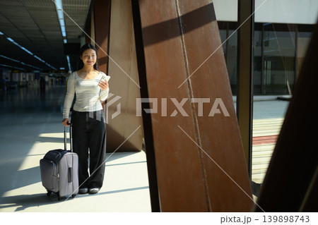 Gen Z traveler using smartphone with suitcase at airport terminal 139898743
