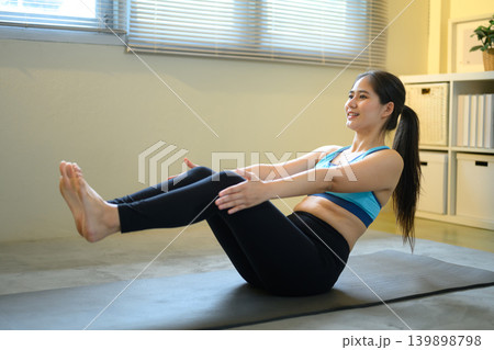 Woman performing core workout on yoga mat at home, healthy lifestyle and fitness training concept Woman performing core workout on yoga mat at home, healthy lifestyle and fitness training concept 139898798