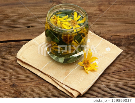 Preparation of tincture from Arnica montana, also known as wolf's bane or  mountain arnica. 139899037
