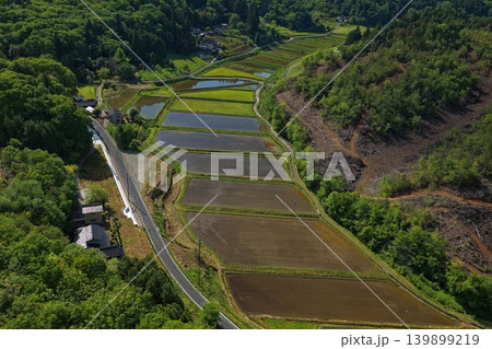 里山の谷間に広がる水田と農地を俯瞰した空撮写真 里山の谷間に広がる水田と農地を俯瞰した空撮写真 139899219