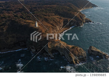 石川県加賀市加佐岬の灯台と断崖海岸を捉えた空撮写真 139899885