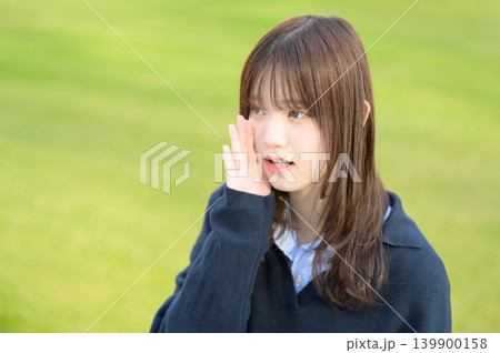 芝生の前で話しかける日本人女子高生 139900158