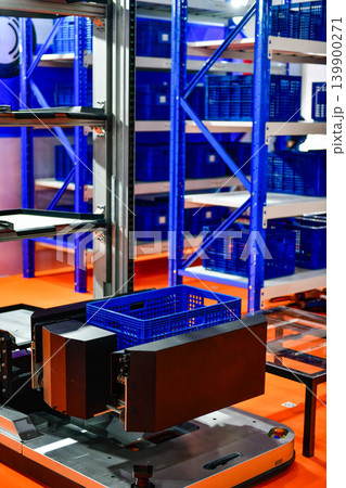 Autonomous robot machine with plastic box in modern industrial warehouse facility. Autonomous robot machine with plastic box in modern industrial warehouse facility. 139900271