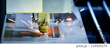 Industrial CNC laser cutter processing steel plate in metalworking factory. 139900274
