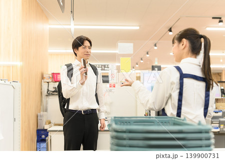 店舗でスマホを提示する客 店舗でスマホを提示する客 139900731