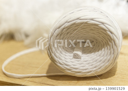 A spool of white cotton rope commonly used for crafts like macrame or as a candle wick 139901529