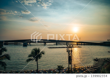 夕暮れ時のフーコック島サンセットタウン。ビーチに並ぶカラフルな椅子とプロポーズの橋 夕暮れ時のフーコック島サンセットタウン。ビーチに並ぶカラフルな椅子とプロポーズの橋 139902354