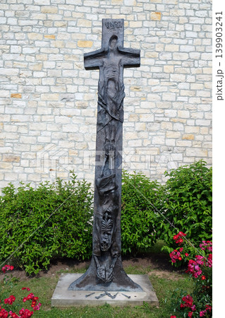 Cross by Sieger Koder in front the Church of Saint Bartholomew in Leutershausen, Germany Cross by Sieger Koder in front the Church of Saint Bartholomew in Leutershausen, Germany 139903241