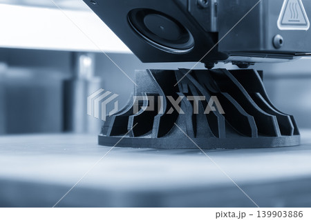 High-precision turbocharger model part produced by advanced 3D printing machine technology in a blue-toned scene. High-precision turbocharger model part produced by advanced 3D printing machine technology in a blue-toned scene. 139903886