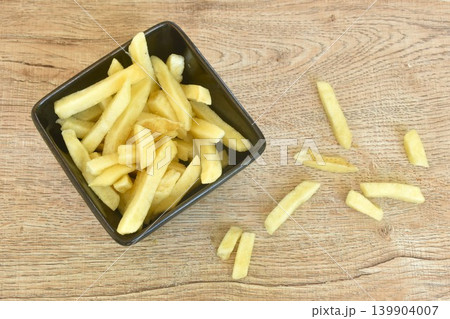 crispy French fries mixed with salt arranging in cup on table crispy French fries mixed with salt arranging in cup on table 139904007