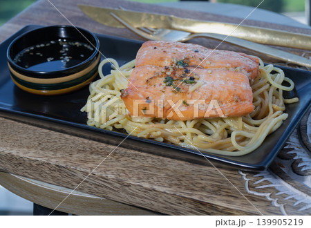 Tender grilled salmon meets masterfully tossed spaghetti, creating a timeless Italian classic infused with rich, coastal flavors. 139905219