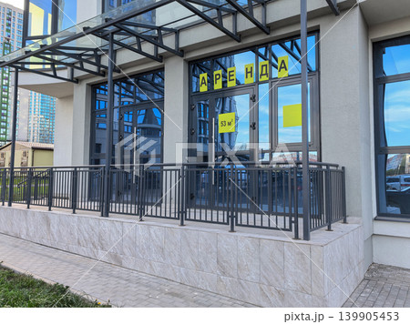 Modern commercial storefront for rent with yellow Russian sign on glass doors 139905453