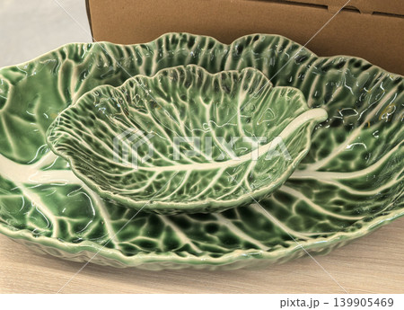 Closeup of green cabbage leaf ceramic bowls with detailed vein texture Closeup of green cabbage leaf ceramic bowls with detailed vein texture 139905469