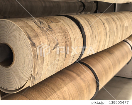 Rolls of brown wood grain vinyl linoleum flooring on warehouse shelves Rolls of brown wood grain vinyl linoleum flooring on warehouse shelves 139905477