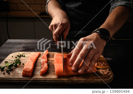 Chief cutting salmon red fish fillet on a cutting board 139905494