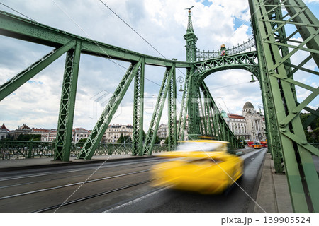 Rushing Yellow Taxi Car Driving Fast By Bridge Over Danube In Bu 139905524