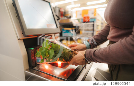 Woman Scanning Fresh Mint In Pot At Self-Service Checkout Woman Scanning Fresh Mint In Pot At Self-Service Checkout 139905544