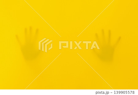 Silhouettes Of Hands Behind Yellow Fabric Silhouettes Of Hands Behind Yellow Fabric 139905578