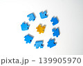 Top view of a gold puzzle piece surrounded by blue pieces in a circular arrangement on white background. Conceptual image for leadership, uniqueness, individuality, and business problem solving. 139905970