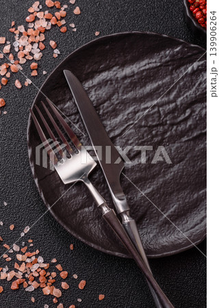 An empty ceramic round plate, kitchen utensils for a dinner table. An empty plate 139906264