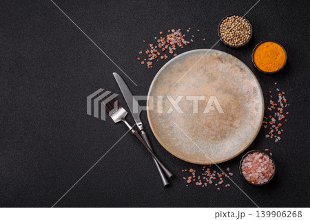 An empty ceramic round plate, kitchen utensils for a dinner table. An empty plate An empty ceramic round plate, kitchen utensils for a dinner table. An empty plate 139906268