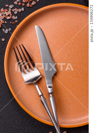 An empty ceramic round plate, kitchen utensils for a dinner table. An empty plate An empty ceramic round plate, kitchen utensils for a dinner table. An empty plate 139906272