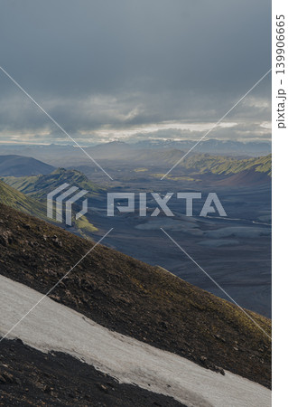 Overcast View of Volcanic Terrain, Snow, and Green Hills in Iceland Overcast View of Volcanic Terrain, Snow, and Green Hills in Iceland 139906665