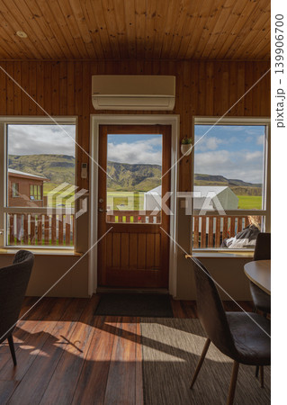Interior of Wooden Cabin with Scenic View of Grassy Fields and Hills 139906700
