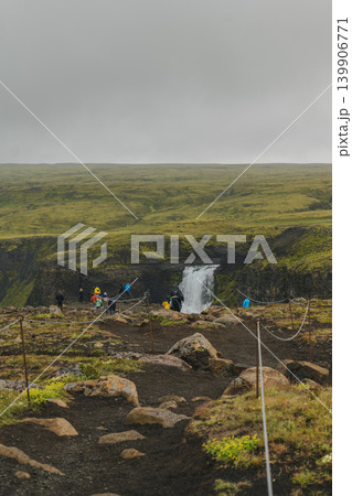 Waterfall Cascading into Canyon with Visitors on Dirt Path in Iceland 139906771