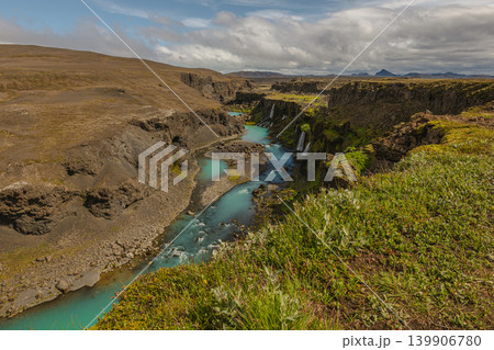 Turquoise River and Waterfalls in an Icelandic Canyon with Mountains Turquoise River and Waterfalls in an Icelandic Canyon with Mountains 139906780