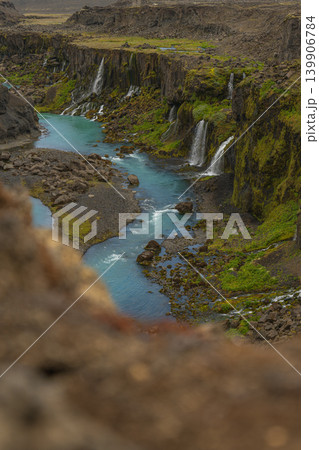 Steep Moss Covered Canyon with Turquoise River and Waterfalls in Iceland 139906784