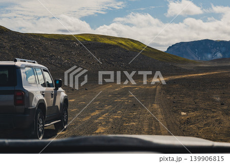 SUV on a Dirt Road in Iceland's Volcanic Highlands with Mossy Hill 139906815