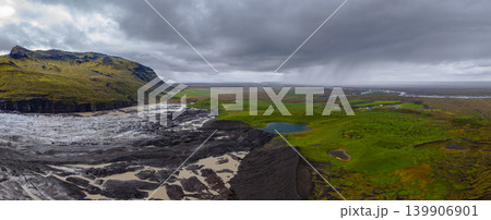 Aerial View of Iceland's Glacier, Volcanic Sediment, and Mossy Mountain 139906901
