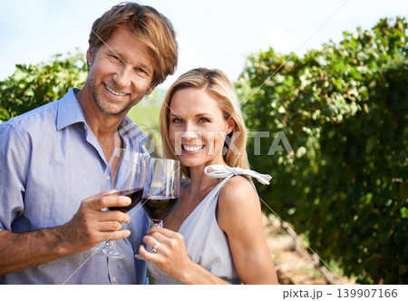 Couple, portrait and drink wine in vineyard, grapes and smile for honeymoon trip in nature for alcohol. People, happiness and standing in farm for agriculture of plants, fruit and together on date Couple, portrait and drink wine in vineyard, grapes and smile for honeymoon trip in nature for alcohol. People, happiness and standing in farm for agriculture of plants, fruit and together on date 139907166