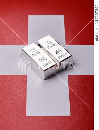 A silver bar, white metal against a backdrop of Swiss flag, as a concept for the sales. A silver bar 139907399